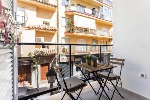 een balkon met een houten tafel en stoelen bij Beach Tapas flat in Fuengirola Old Town Ref 182 in Fuengirola