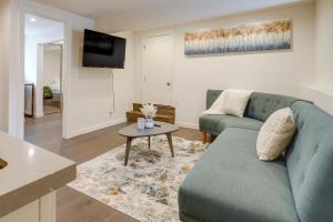 Una sala de estar con un sofá azul y una mesa. en Efficiently Equipped Pacifica Apt - 1 Mi to Beach!, en Pacífica