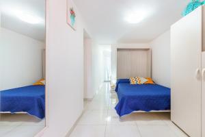 2 Betten in einem weißen Zimmer mit blauer Bettwäsche in der Unterkunft casetta mariapia in Procida