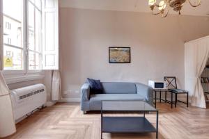 a living room with a blue couch and a window at Ginori 3P in Florence