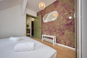 ein Schlafzimmer mit einem weißen Bett und einer roten Wand in der Unterkunft M&D ZAGREB CITY CENTER quiet suites in Zagreb