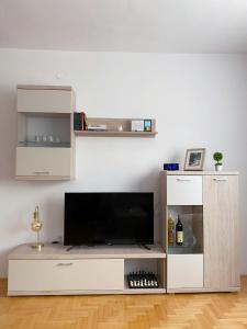 ein Wohnzimmer mit einem Flachbild-TV auf einem Entertainment-Center in der Unterkunft Apartment Varezić in Plužine