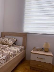ein Schlafzimmer mit einem Bett und einem Tisch mit einer Lampe in der Unterkunft Apartment Varezić in Plužine