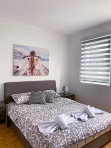 ein Schlafzimmer mit einem Bett mit einem Bild an der Wand in der Unterkunft Apartment Varezić in Plužine