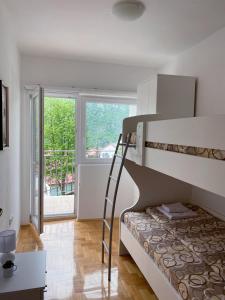 a bedroom with a bunk bed and a balcony at Apartment Varezić in Pluzine