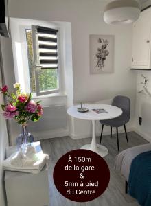 um pequeno quarto branco com uma mesa, uma mesa e uma cadeira em Studio Le Flore - Petit déjeuner inclus 1ère nuit - AUX 4 LOGIS em Foix