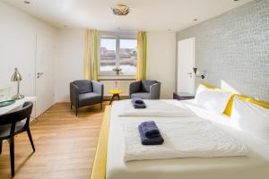 a hotel room with a bed and a desk and chairs at Strandhotel Achtert Diek in Langeoog