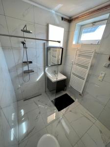 a white bathroom with a sink and a toilet at Müller's 1 in Siófok