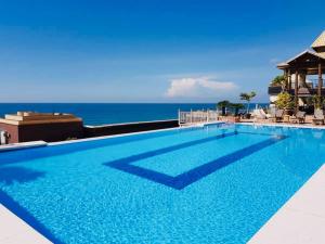 una gran piscina con el océano en el fondo en Beach Front Penthouse in Exclusive Tower en Santo Domingo