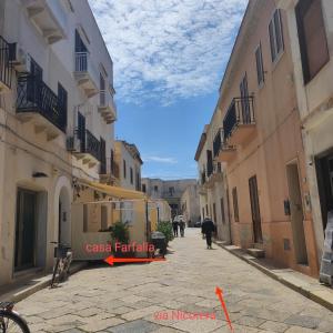 een straat met gebouwen en mensen die over straat lopen bij CASA FARFALLA in Favignana