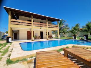 a villa with a swimming pool in front of a house at Casa Ferreira Cumbuco in Caucaia