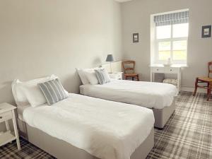 1 Schlafzimmer mit 2 Betten und einem Fenster in der Unterkunft Lagoon View - Sea View- Pet Friendly - 2 Bed Apt - En-suite in Trearddur