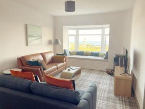 ein Wohnzimmer mit einem Sofa und einem TV in der Unterkunft Lagoon View - Sea View- Pet Friendly - 2 Bed Apt - En-suite in Trearddur