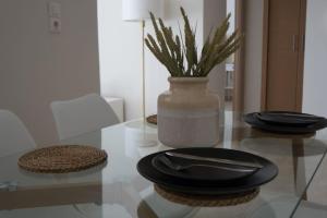 un tavolo di vetro con piatti e un vaso sopra di Central Delight a Calcide