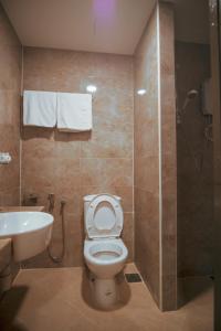 a bathroom with a toilet and a shower and a sink at Hotel Ambassador @ Bukit Bintang in Kuala Lumpur