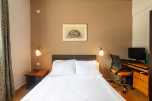 um quarto de hotel com uma cama, uma secretária e um computador em Geo city center room em Atenas