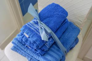 una pila di asciugamani blu con un coltello in cima di casetta mariapia a Procida
