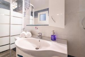 a white bathroom with a sink and a mirror at Geo city center room in Athens