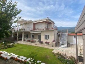 a large house with a balcony and a yard at Lovely House by the Sea with Garden and BBQ (A) in Platanidia