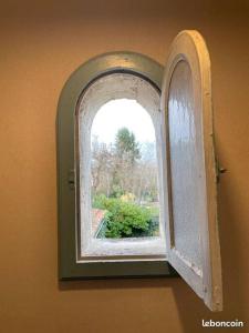 an open window in a room with a garden outside at Charmant Gite 6p. Périgord Vert in Mareuil-sur-Belle