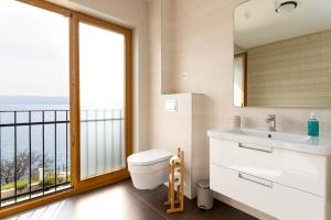 a bathroom with a toilet and a sink and a window at Großzügiges Appartement direkt am Meer mit eigenem Pool - Povile Suites in Novi Vinodolski +30 photos