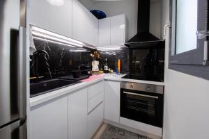 a kitchen with white cabinets and black appliances at Athens luxurious loft in Athens