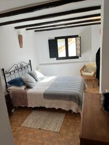 1 dormitorio con cama y ventana en Casa idrisi, en Albuñuelas