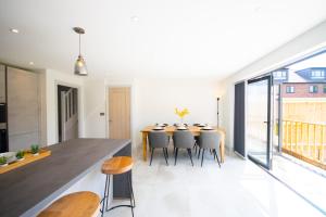eine Küche und ein Esszimmer mit einem Tisch und Stühlen in der Unterkunft Princes Close - Spacious Modern Luxury Home in Windsor