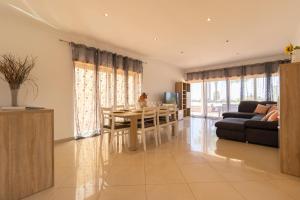 sala de estar con mesa y sofá en Luxury Villa Albufeira, en Albufeira