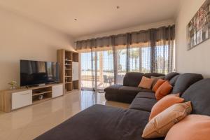 Il comprend un salon doté d'un canapé et d'une télévision à écran plat. dans l'établissement Luxury Villa Albufeira, à Albufeira