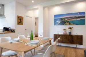a dining room with a wooden table and white chairs at Apartamento con Jardín en el Oviedo Antiguo in Oviedo +20 photos
