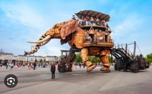 a large elephant float in a parade in a city at Chambre privée avec SDB attenante in Vertou