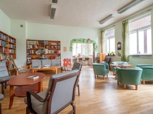 ein Zimmer mit Stühlen und Tischen in einer Bibliothek in der Unterkunft Körsbärskullen in Vimmerby