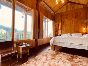 a bedroom with a bed and a large window at A Phủ Home's Tà Xùa in Bắc Yên