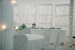 a white table with white chairs and christmas lights at The Hudson Inn in Morris