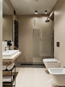 W łazience znajduje się umywalka, toaleta i prysznic. w obiekcie Hoppen House Apartamenty w centrum miasta w Radomiu