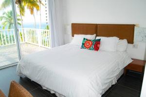 1 dormitorio con 1 cama y vistas al océano en Apto. en condominio con playa privada., en Santa Bárbara de Samaná