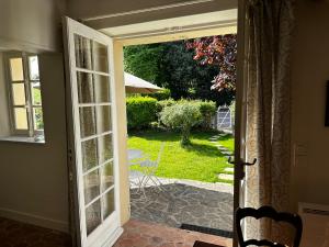 eine offene Tür mit Blick auf einen Hof in der Unterkunft Cottage Vesqueville in La Hoguette