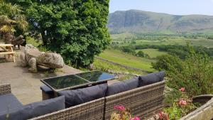 a patio with a couch and a laptop on it at Windsor Farm House near Scafell in Nether Wasdale