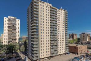 a large white apartment building in a city at Superb 2 bedroom downtown with river view in Saskatoon