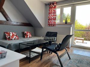 uma sala de estar com um sofá, uma mesa e cadeiras em Słoneczny Wodnik em Braniewo