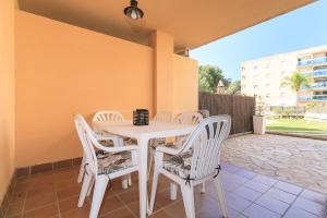 a white table and chairs on a patio at UHC Golden Pineda Apartments in Salou
