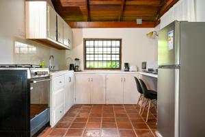 een keuken met witte kasten en een zwarte koelkast bij The Cottages - Unit 2 in Soufrière
