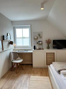 um quarto com uma secretária, uma cama e uma janela em lóuf em Wiesmoor