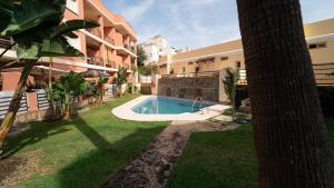 a swimming pool in a yard next to a building at Suite Añoreta Malaga Parking 101 in Torre de Benagalbón