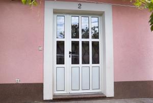 uma porta branca num edifício cor-de-rosa em MiKa em Kaštela