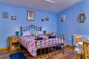 a bedroom with a bed with blue walls at Finest Retreats - New Inn Lodge in East Dereham