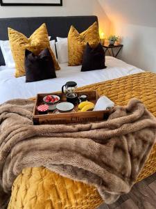 a tray of food on top of a bed at *BRAND NEW* Luxury Country Lodge in Burnham-on-Crouch