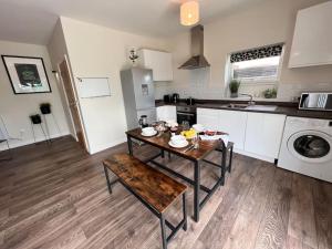 a kitchen with a wooden table and a kitchen with a sink at *BRAND NEW* Luxury Country Lodge in Burnham on Crouch