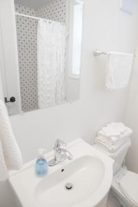 a white bathroom with a sink and a mirror at 2Bdrm Victorian Style Tiny Home - long stays U7 in Burlington